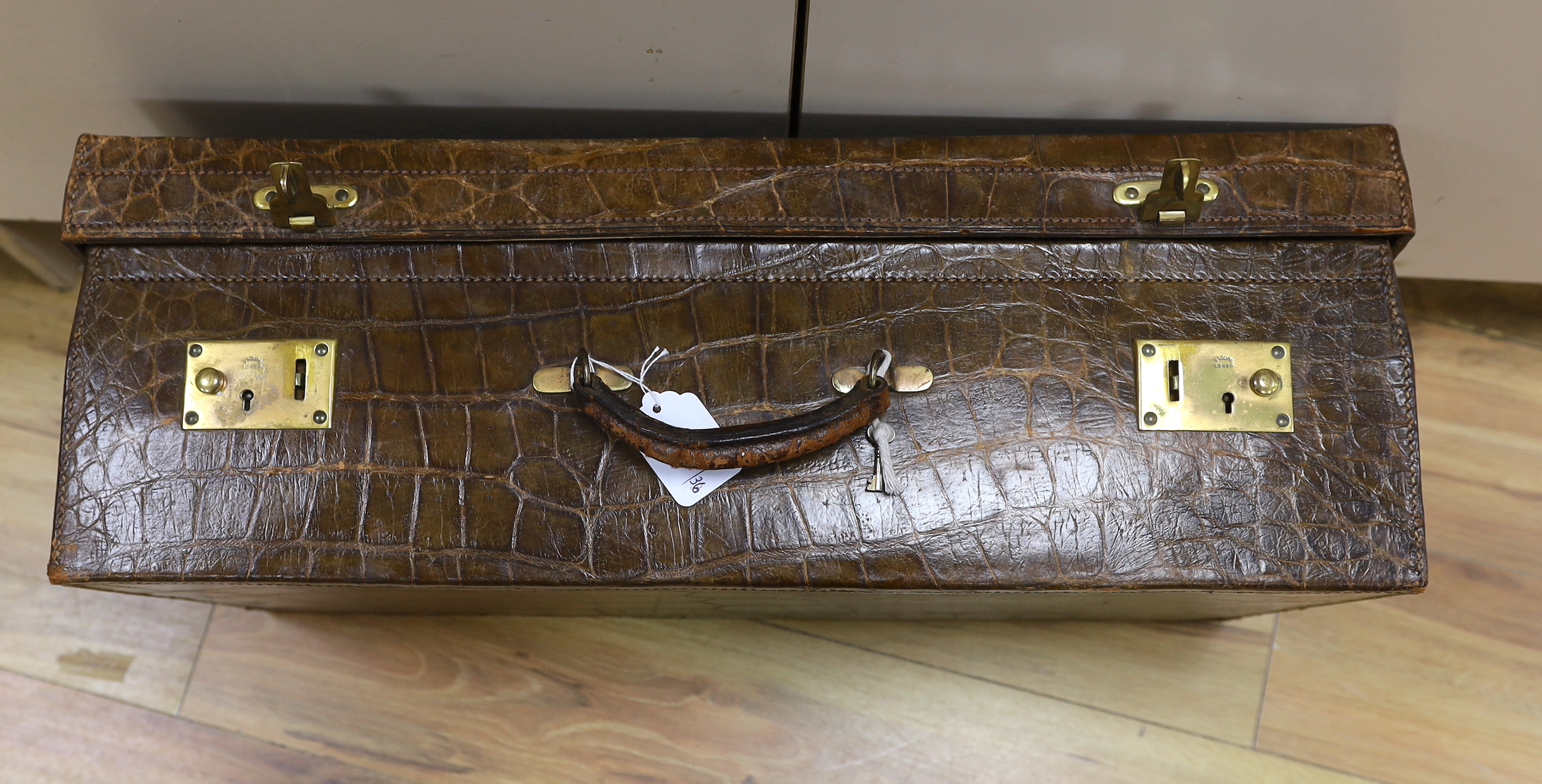 A Vintage 1930’s crocodile skin travelling case, 65cm wide